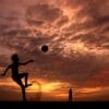 silhouette of a boy playing ball during sunset