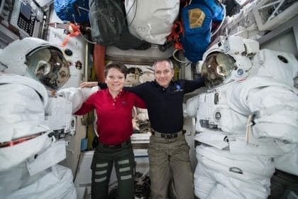 Los astronautas Anne McClain y David Saint Jacques fotografiados entre un par de trajes espaciales dentro de la esclusa de aire de Quest, donde se guardan los trajes espaciales. Image Credit: NASA