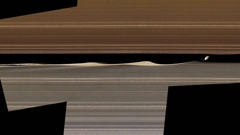 Un mosaico de imágenes en color falso muestra a Daphnis, una de las lunas con anillos incrustados de Saturno, y las ondas que levanta en la brecha de Keeler. Las imágenes recopiladas por las órbitas cercanas de Cassini en 2017 ofrecen nuevas perspectivas sobre el complejo funcionamiento de los anillos. Image Credit: NASA/JPL-Caltech/Space Science Institute