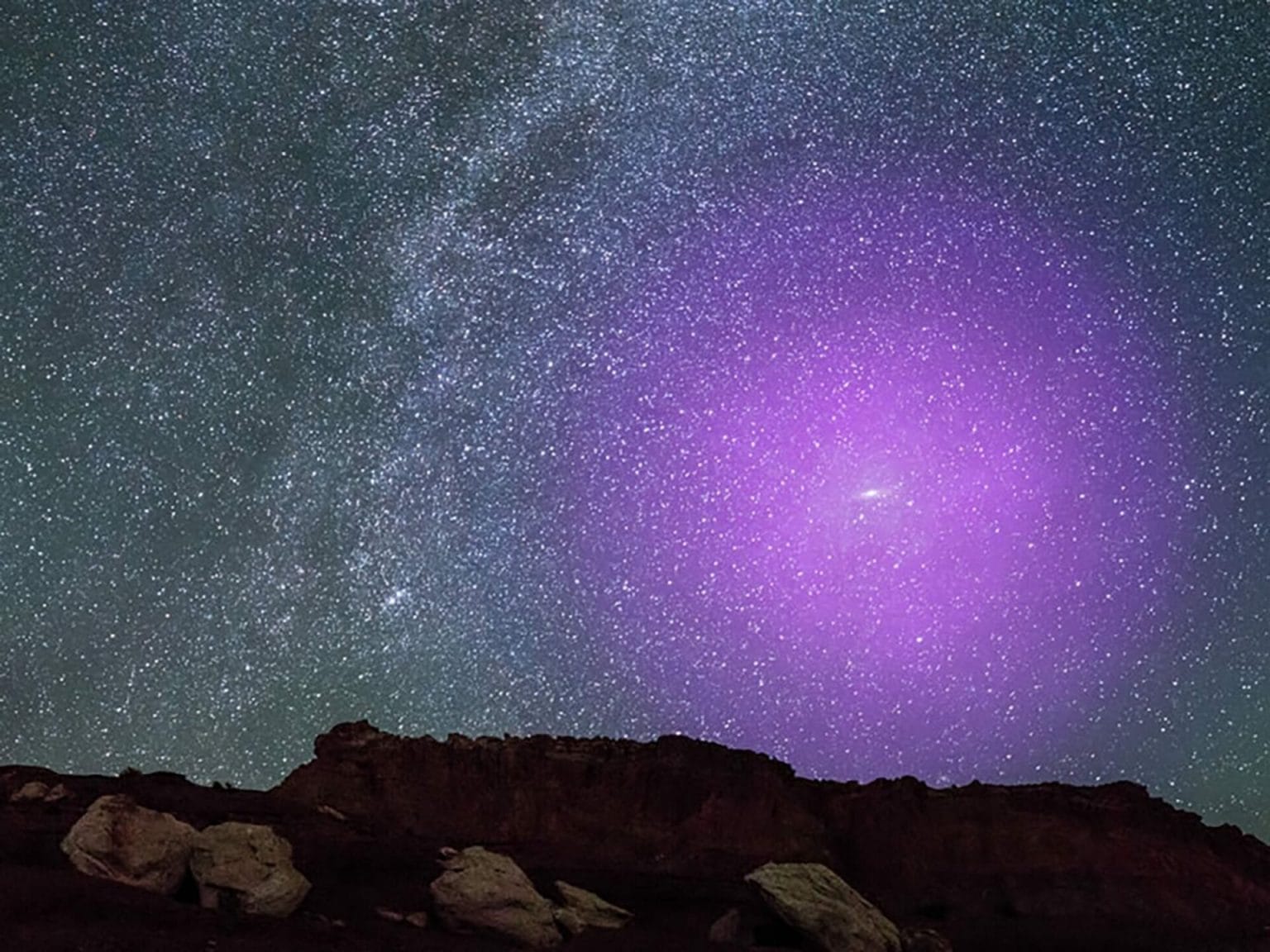 Esta ilustración muestra el halo gaseoso de la galaxia de Andrómeda si pudiera verse a simple vista. A una distancia de 2,5 millones de años luz, la majestuosa galaxia espiral de Andrómeda está tan cerca de nosotros que aparece como una mancha de luz en forma de cigarro en lo alto del cielo otoñal. Si su halo gaseoso pudiera verse a simple vista, sería aproximadamente tres veces el ancho que la Osa Mayor, fácilmente la característica más grande del cielo nocturno. Credits: NASA, ESA, J. DePasquale y E. Wheatley (STScI) y Z. Levay (imagen de fondo)