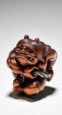 A wood netsuke of an oni (demon) holding a metal cord, 18th century sold for €38,400 (estimate: €12,000-€18,000)